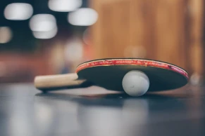 an old racket with a table tennis ball